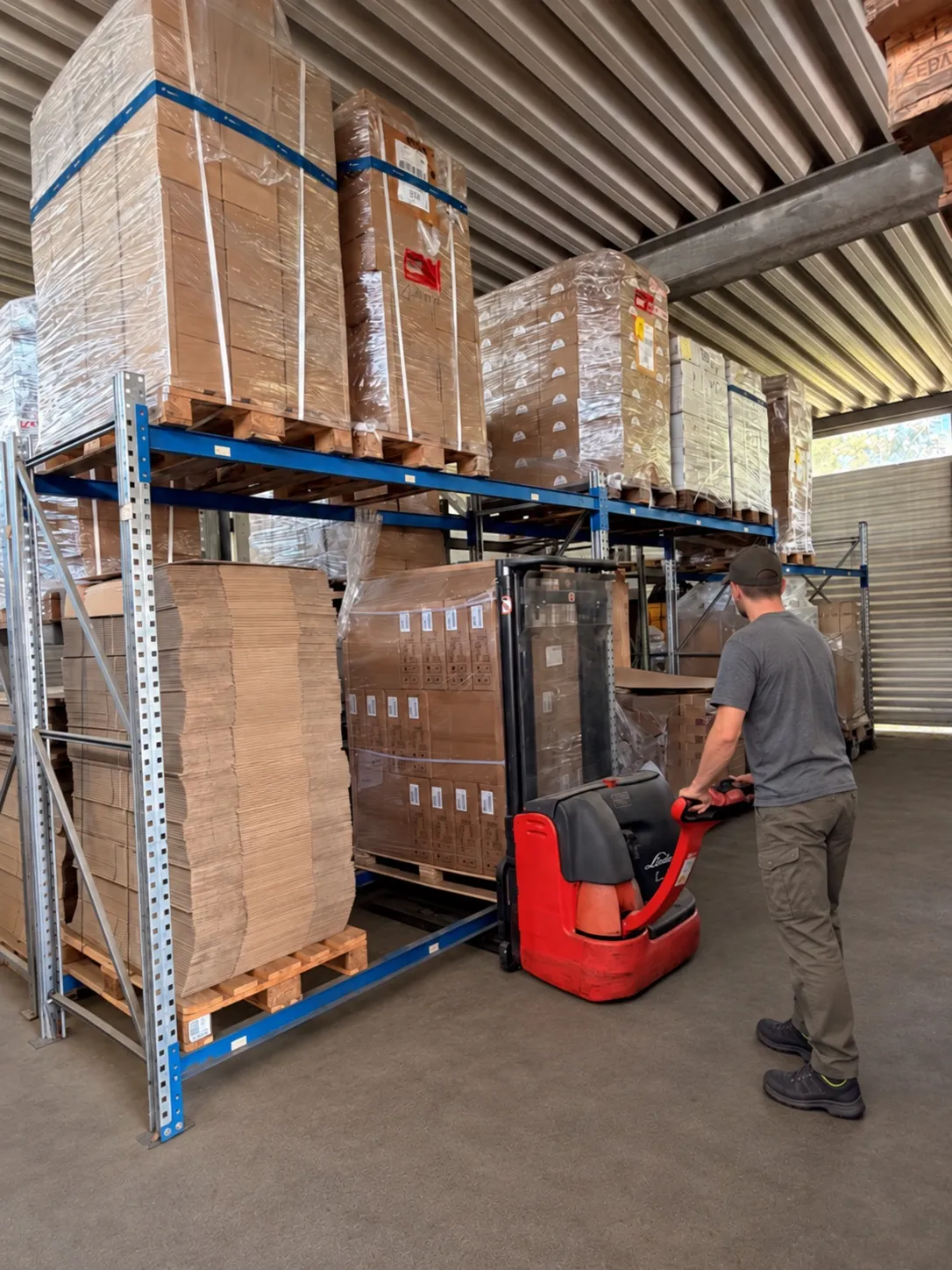 Mitarbeiter bewegt eine Palette am Hochregal im Lager der Hans WiNN GmbH & Co. KG in Bamberg